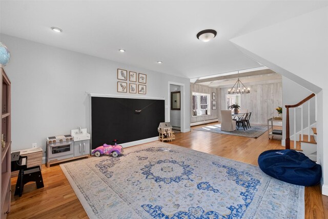 living room with recessed lighting, wood finished floors, stairs, baseboard heating, and an inviting chandelier