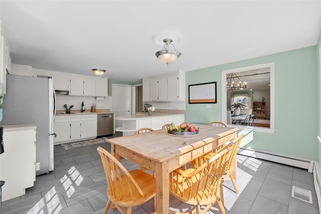 dining room featuring a chandelier and baseboard heating