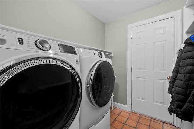 clothes washing area with washing machine and dryer, laundry area, and baseboards