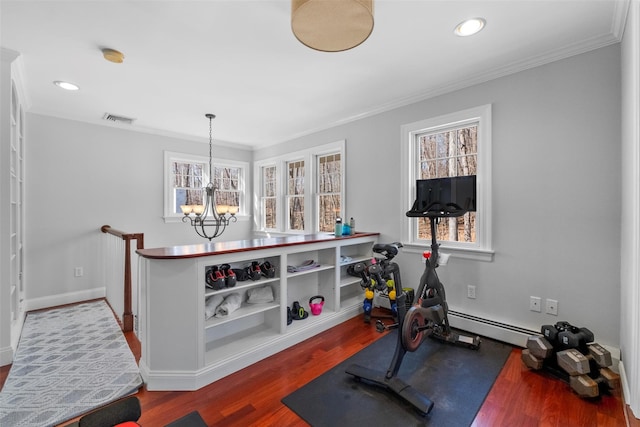 workout room featuring a chandelier, a baseboard radiator, wood finished floors, visible vents, and ornamental molding