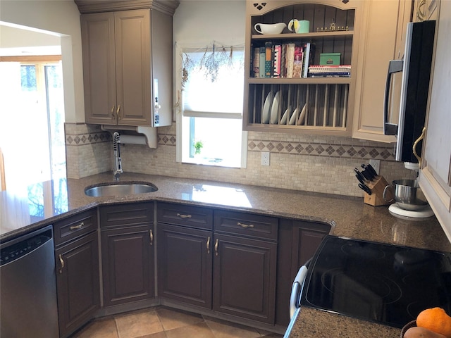 kitchen featuring tasteful backsplash, range with electric cooktop, dark stone countertops, stainless steel dishwasher, and a sink