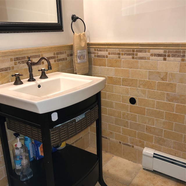 bathroom with a baseboard heating unit, wainscoting, tile walls, and vanity