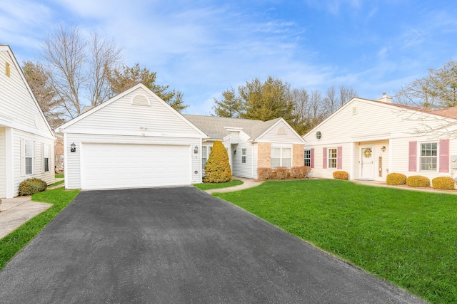 view of front of house with driveway, an attached garage, and a front yard