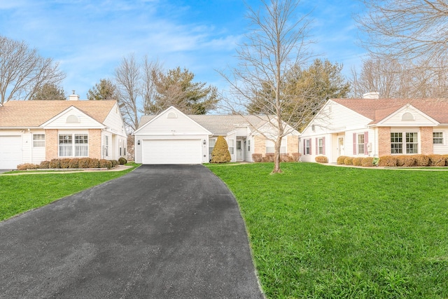 view of front of house with aphalt driveway, a front yard, and an attached garage