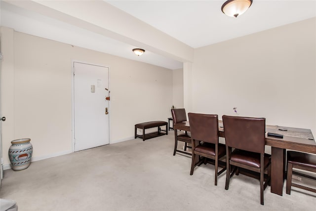 dining area with baseboards and light colored carpet