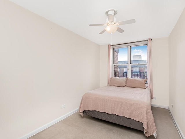 bedroom featuring light colored carpet, ceiling fan, and baseboards