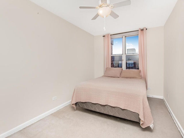 bedroom with light carpet, a ceiling fan, and baseboards