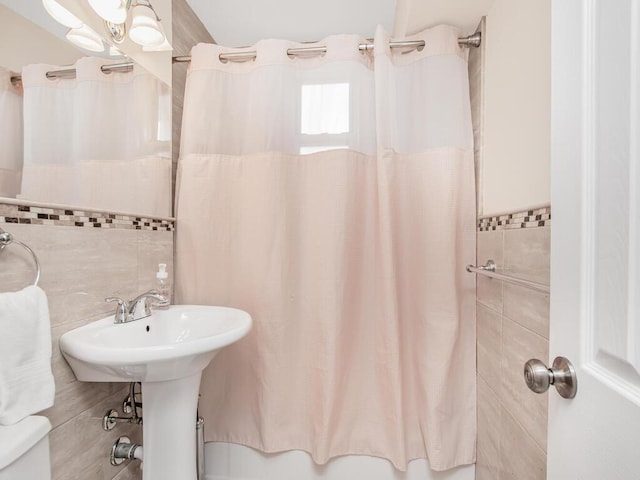 full bathroom with shower / bath combo and tile walls