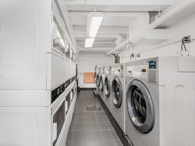 common laundry area with stacked washing maching and dryer, washing machine and dryer, and dark tile patterned flooring