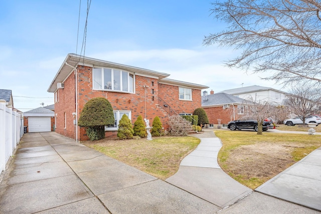 view of front of house with brick siding, a detached garage, fence, an outdoor structure, and a front lawn