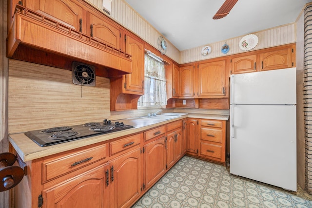 15744 97th St, Howard Beach, NY 11414 - kitchen with black electric stovetop, light countertops, brown cabinetry, freestanding refrigerator, and ceiling fan