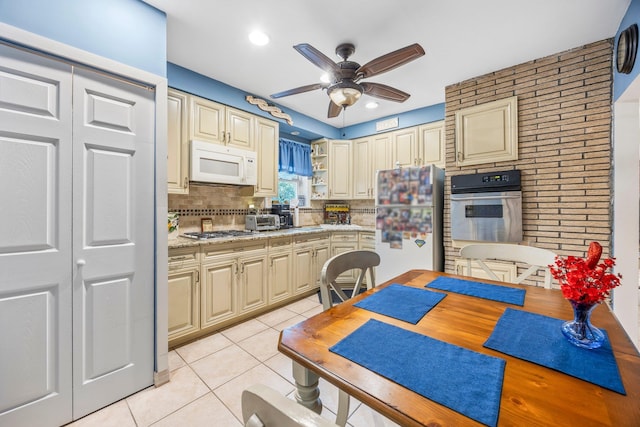15744 97th St, Howard Beach, NY 11414 - kitchen with light tile patterned floors, cream cabinets, a ceiling fan, light countertops, and appliances with stainless steel finishes