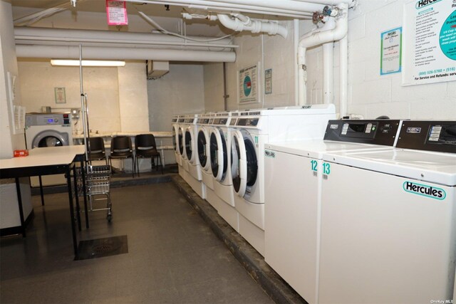 shared laundry area with washer and clothes dryer and concrete block wall