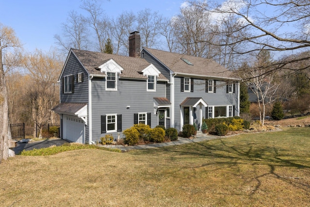 colonial inspired home with fence, aphalt driveway, a front yard, a chimney, and a garage