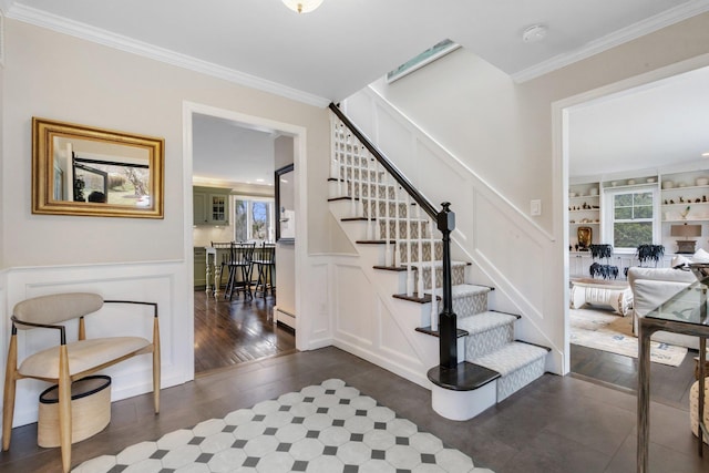 staircase featuring a baseboard radiator, wood finished floors, and crown molding