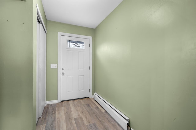 doorway featuring light wood-style flooring, baseboards, and baseboard heating