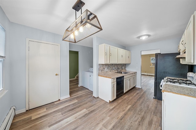 kitchen featuring decorative backsplash, washer and clothes dryer, baseboard heating, light countertops, and a sink