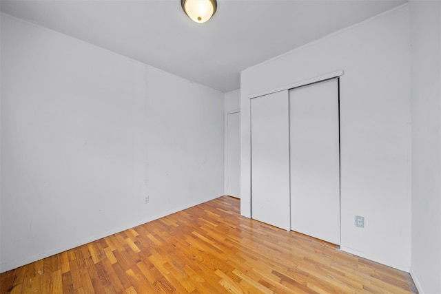 unfurnished bedroom with a closet and light wood-style flooring