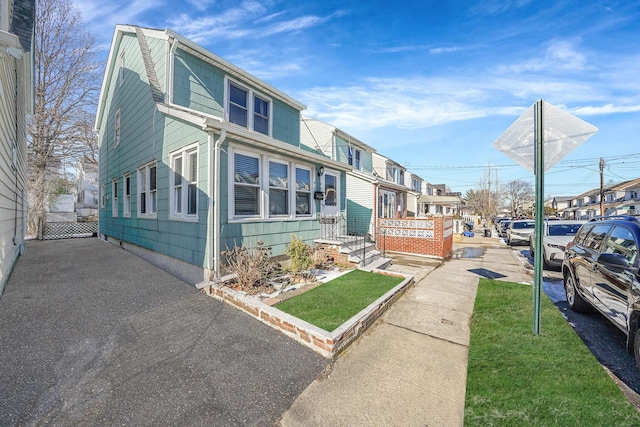 view of front facade featuring a front yard, fence, and a residential view