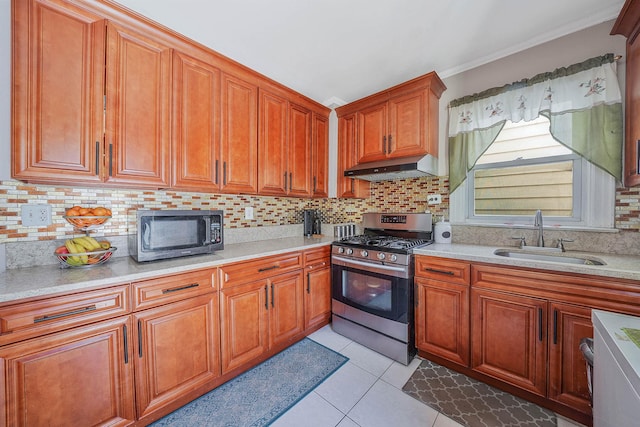 kitchen featuring light tile patterned floors, stainless steel gas range oven, extractor fan, light countertops, and a sink