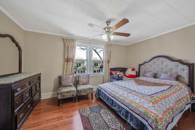 bedroom with crown molding, ceiling fan, baseboards, and light wood-style floors