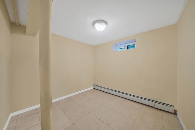 basement with light tile patterned floors, a baseboard radiator, and baseboards