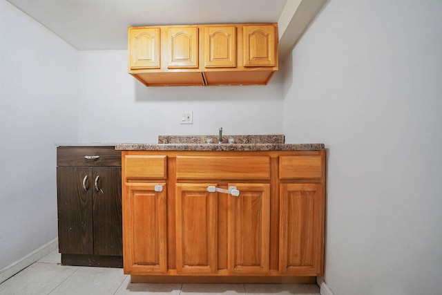 details featuring indoor wet bar, a sink, and baseboards