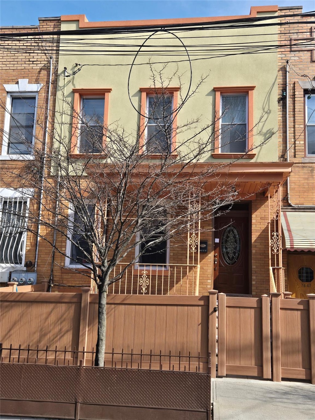 multi unit property with stucco siding, a fenced front yard, a gate, and brick siding