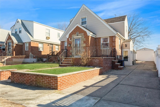 view of front facade with an outbuilding, brick siding, a front yard, and fence