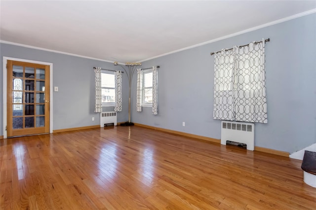 interior space featuring ornamental molding, light wood-type flooring, radiator, and baseboards