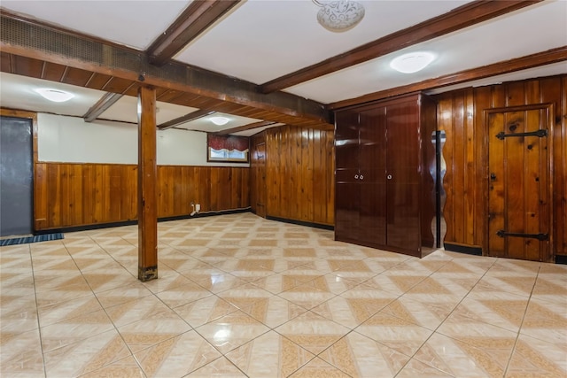 finished basement featuring light tile patterned flooring and wood walls