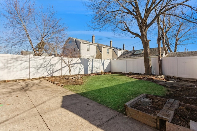 view of yard with a garden, a fenced backyard, and a patio