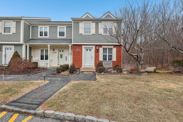 multi unit property featuring a front lawn and brick siding