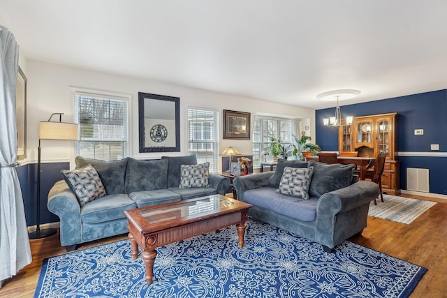 living area with a chandelier, wood finished floors, and baseboards