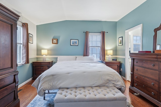 bedroom featuring vaulted ceiling, baseboards, and wood finished floors