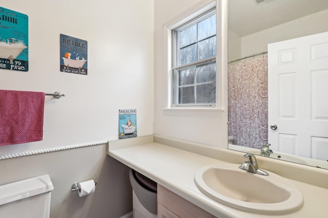 full bathroom featuring curtained shower, vanity, and toilet