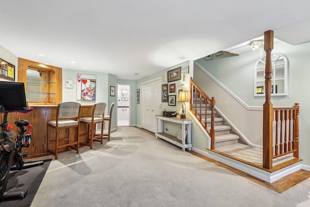 interior space featuring a dry bar, baseboards, stairway, and recessed lighting