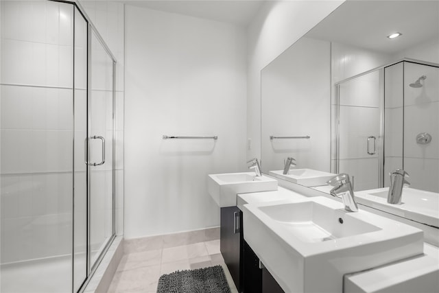 bathroom featuring a stall shower, a sink, baseboards, and tile patterned floors