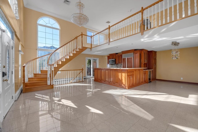 unfurnished living room featuring stairs, a high ceiling, a healthy amount of sunlight, and baseboards