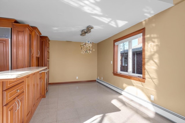 unfurnished dining area featuring a baseboard heating unit and baseboards