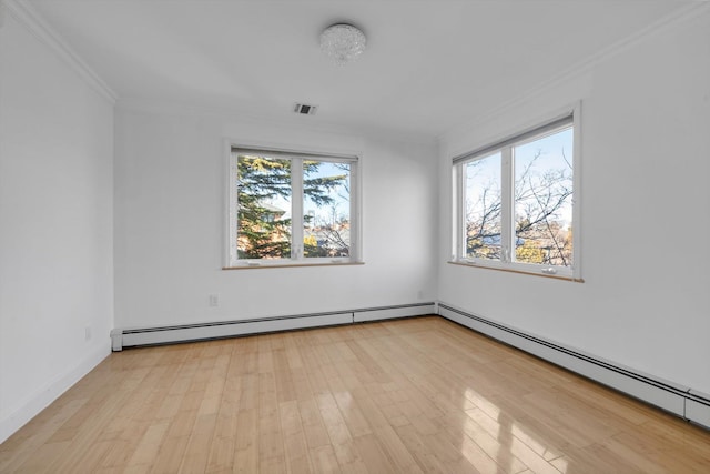 empty room with a baseboard heating unit, plenty of natural light, wood finished floors, and visible vents