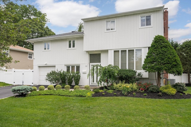 view of front of house with aphalt driveway, cooling unit, a garage, fence, and a front yard