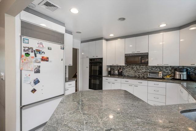 kitchen with visible vents, white cabinetry, decorative backsplash, black appliances, and dark stone countertops