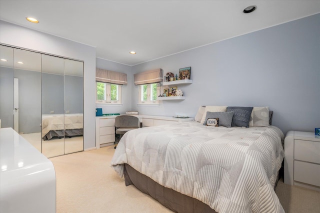 bedroom with recessed lighting, a closet, and light carpet