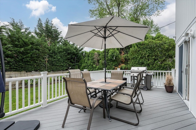 wooden deck featuring a yard, fence, area for grilling, and outdoor dining space