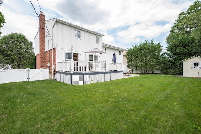 rear view of house featuring a gate, a yard, a chimney, and fence