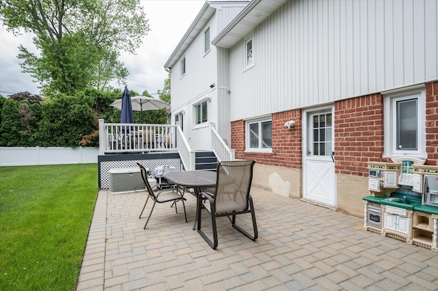 view of patio / terrace with a deck, outdoor dining area, and fence