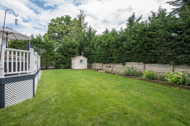 view of yard featuring an outbuilding, a fenced backyard, and a storage shed