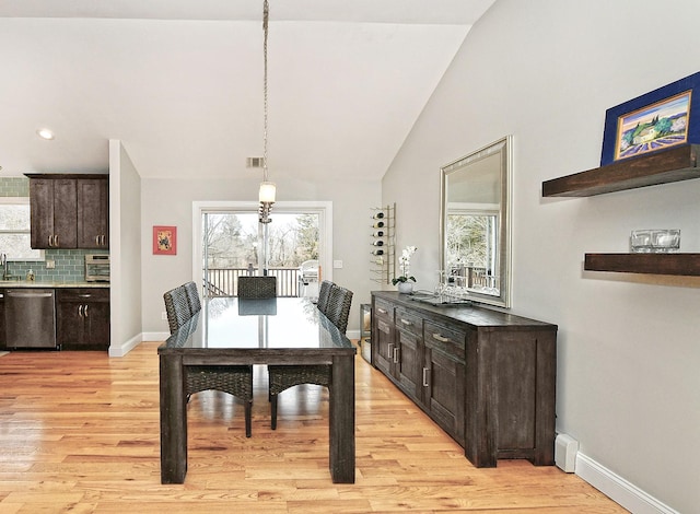 dining space with vaulted ceiling, plenty of natural light, light wood-style flooring, and baseboards