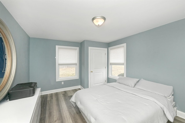 bedroom with dark wood finished floors and baseboards